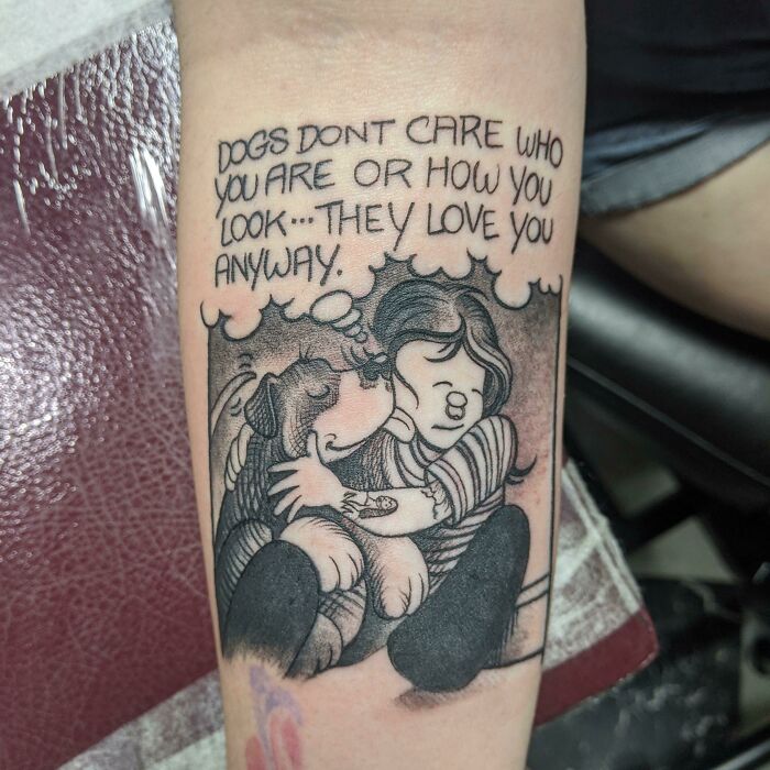 Tattoo of a child hugging a dog with text: "Dogs don't care who you are...they love you anyway." Immortalizing a pet.