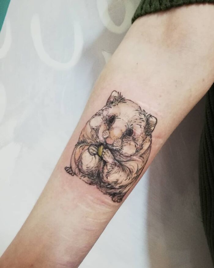 Tattoo of a detailed hamster on a person's forearm, celebrating the bond between humans and pets.