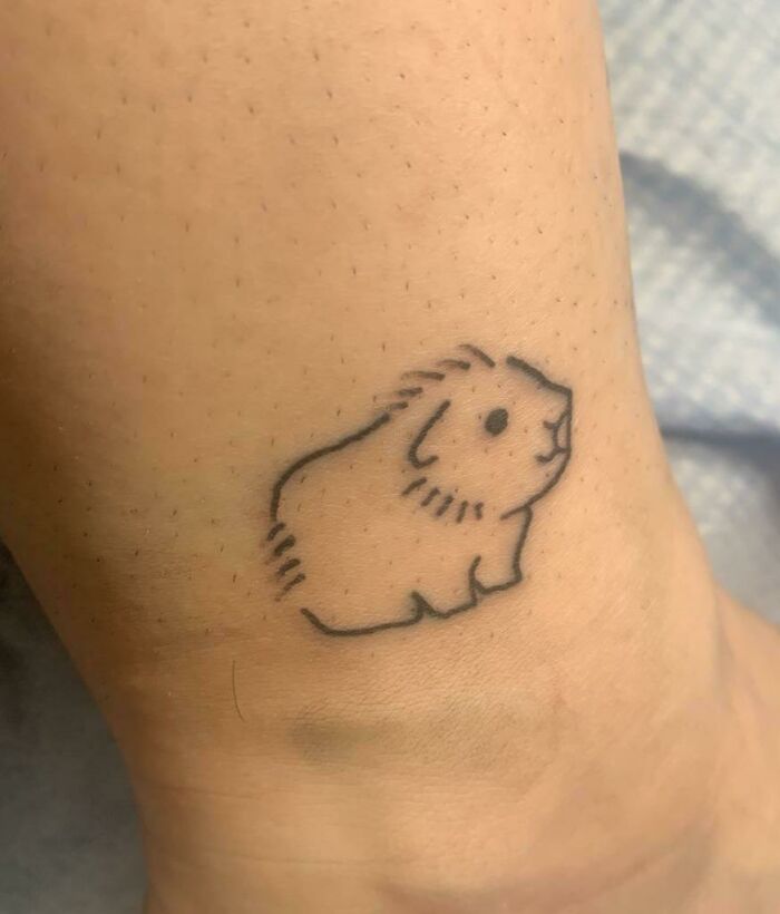 Simple pet tattoo of a small animal on human skin, symbolizing an adorable bond with a beloved pet.