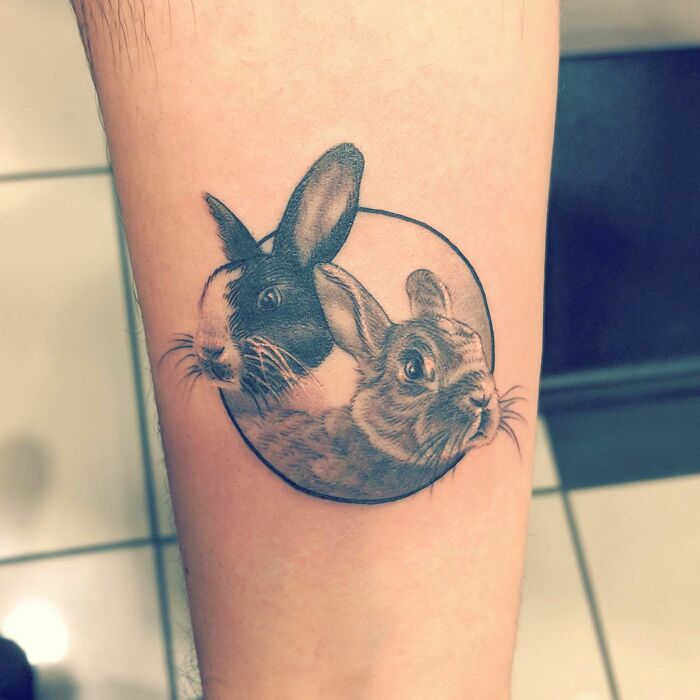 Pet tattoo of two rabbits in a circle, symbolizing the bond between humans and their pets.