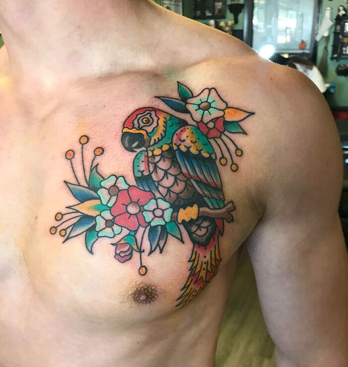 Colorful pet tattoos featuring a parrot with flowers on a person's chest, celebrating furry friends.