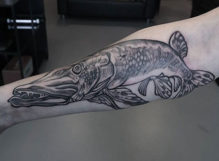 Forearm with detailed animal tattoo of a fish, showcasing unique animal tattoo design inspiration.