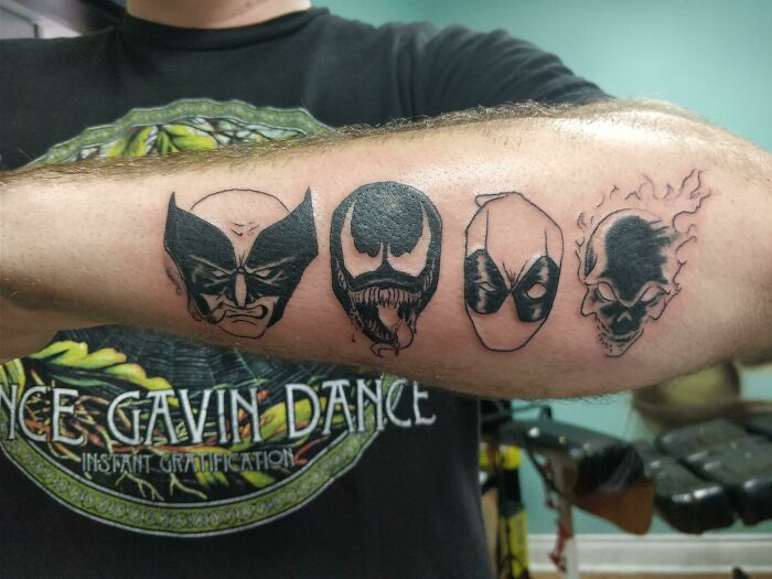 Marvel tattoos featuring iconic character faces on forearm.