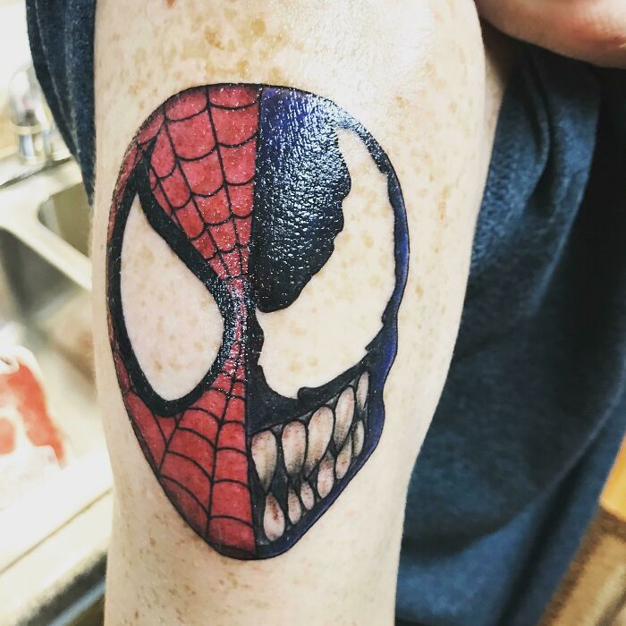 Marvel tattoo featuring a split design of Spider-Man and Venom on an arm.