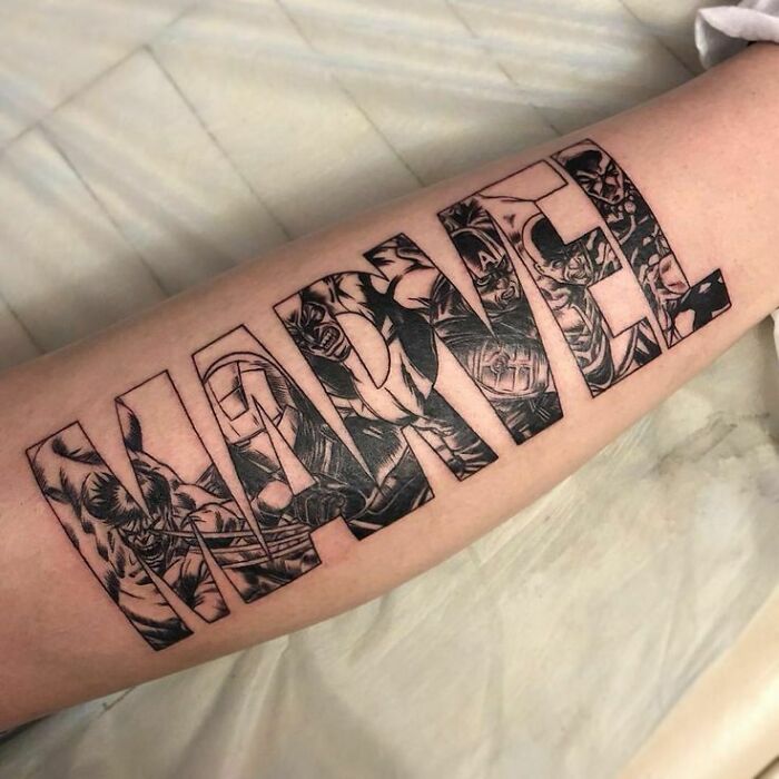 Arm tattoo featuring the word "Marvel" with intricate superhero designs inside the letters.