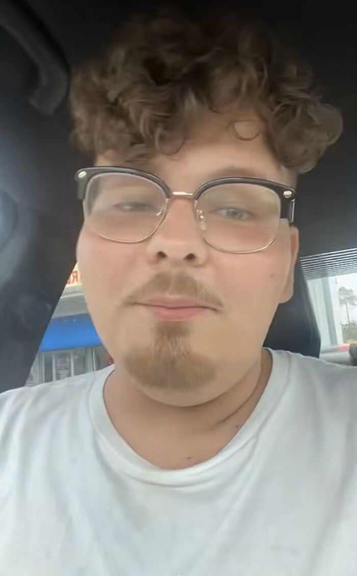 Man with glasses showcasing a unique curly hairstyle in a casual setting, exemplifying bad haircut ideas.