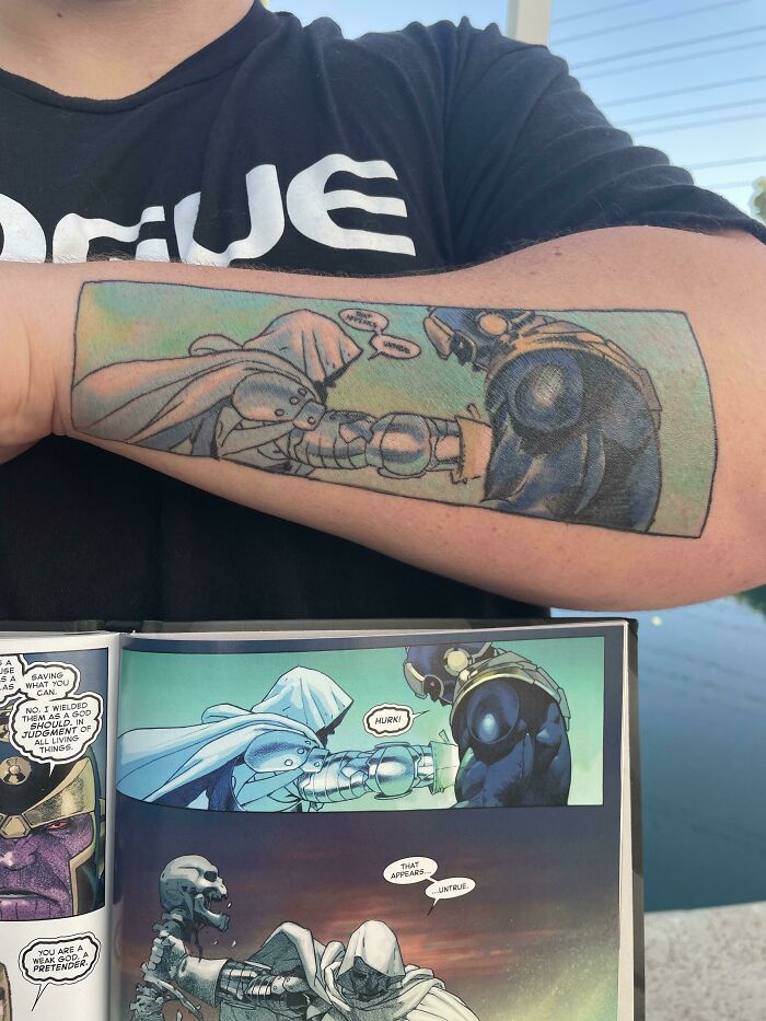 Marvel tattoo featuring a comic panel scene on a forearm, showcasing two characters clashing in vibrant colors.