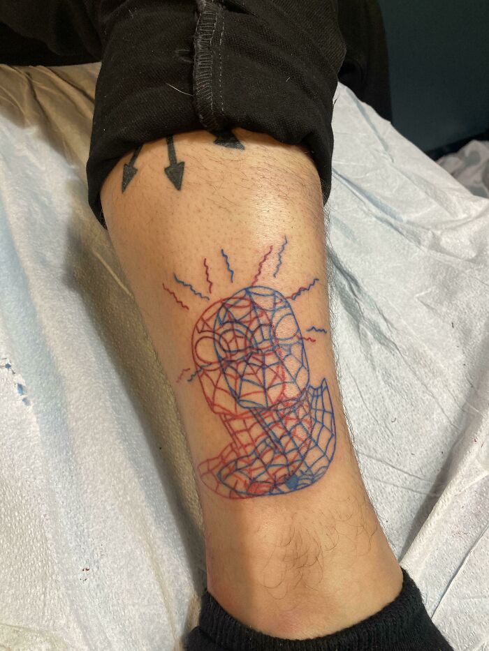 Marvel tattoo featuring a geometric design on a person's leg, showcasing Spider Man patterns in red and blue.