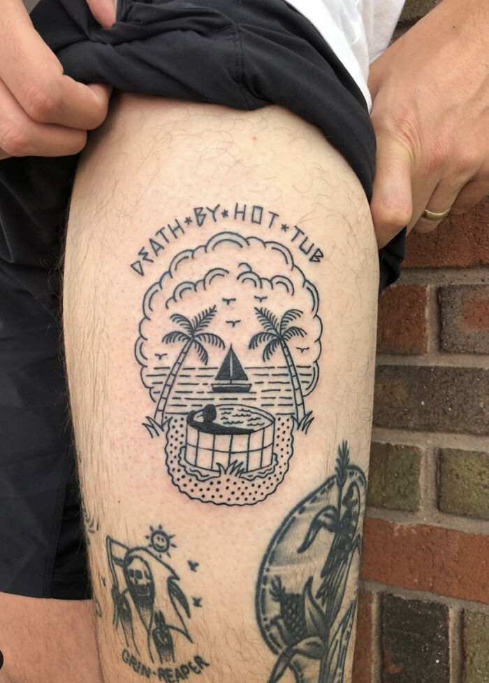 Creative word tattoo on leg featuring a beach scene with palm trees and the phrase "Death by Hot Tub."