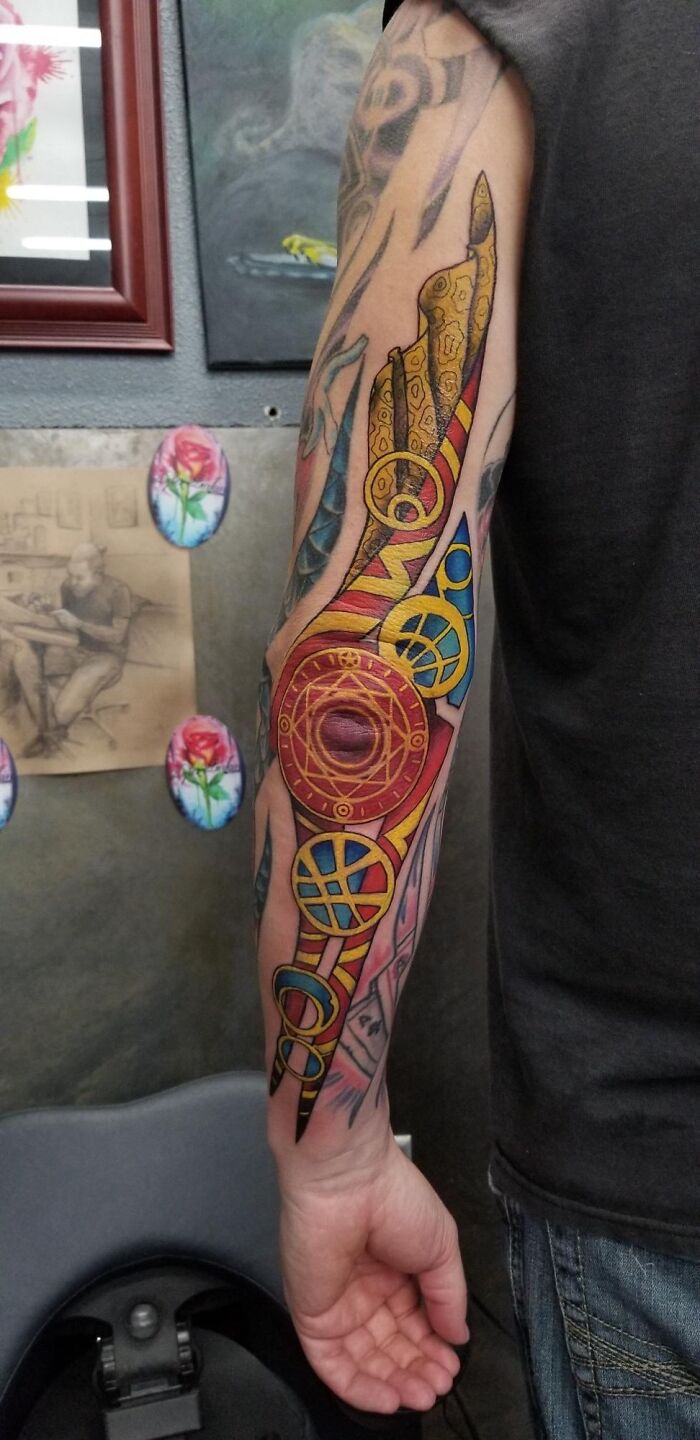 Colorful Marvel-inspired tattoo on a forearm featuring intricate designs and patterns.