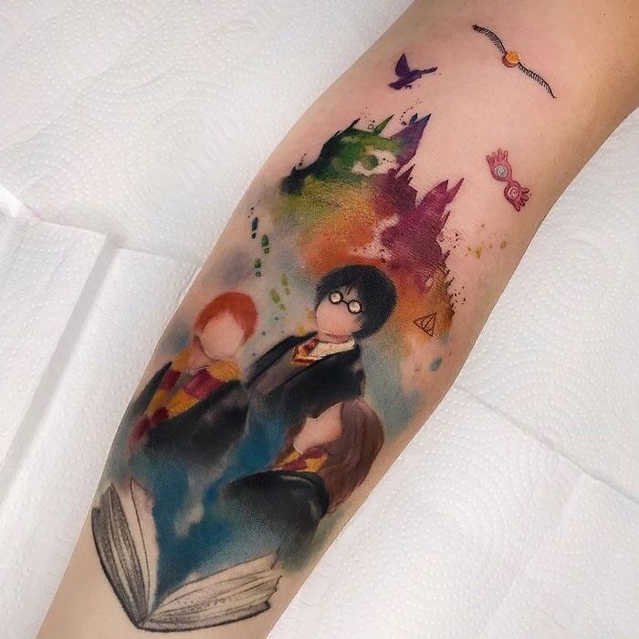 Colorful Harry Potter tattoo with characters and iconic symbols from the Wizarding World on an arm.