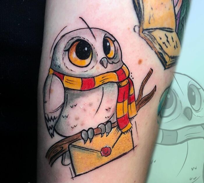 Cute owl tattoo with a red and yellow scarf, holding an envelope, inspired by Harry Potter.