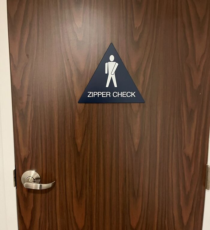 This Zipper Check Sign On The Backside Of The Door Of A Hotel’s Lobby Bathroom