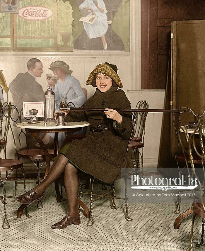 Woman in early 20th century attire sitting in a cafe, highlighting big historical events from around a century ago.
