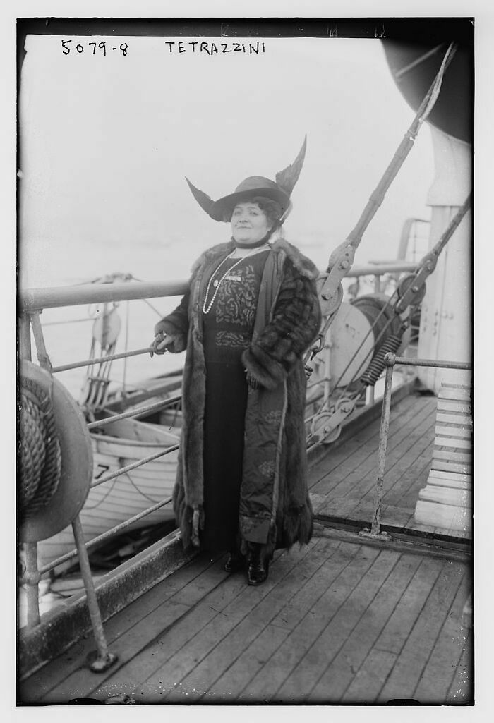Early 20th century woman in fur coat and elaborate hat standing on ship deck, representing big historical events.