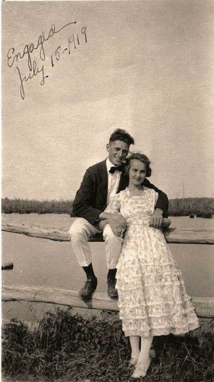 Couple posing outdoors near a lake in 1919, representing a big historical event from around a century ago.