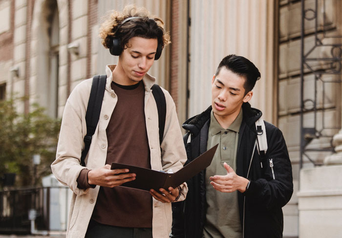 Friends watching book in the street