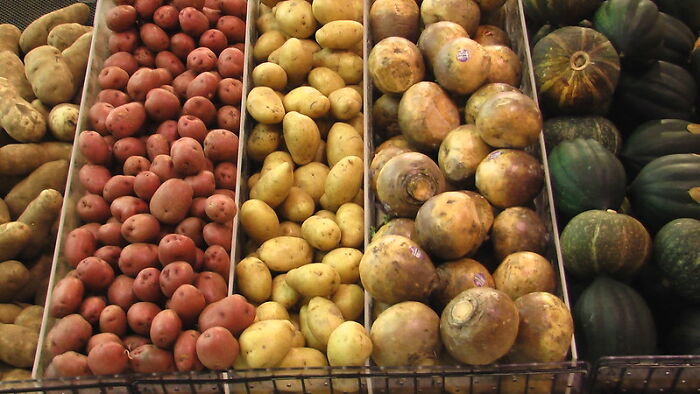 Variety of potatoes and squash displayed in bins, illustrating unexpected things that could be considered a crime.