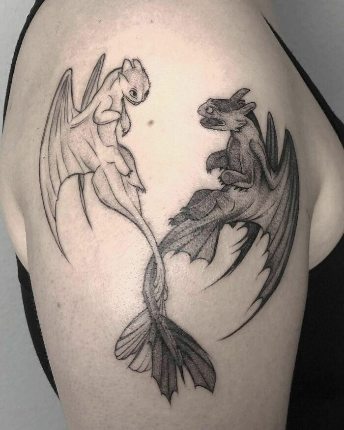 Cartoon dragon tattoo on arm, showcasing detailed line art and shading for a nostalgic design.