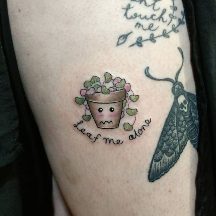 Cute plant pot tattoo with text "Leaf me alone" and moth design, tattoo ideas for new ink.