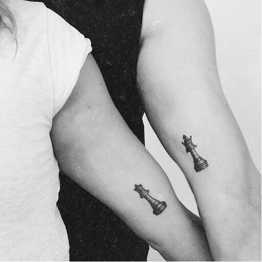 Simple brother and sister tattoos with matching chess pieces inked on arms.