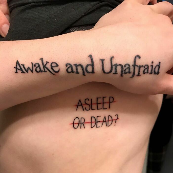 "Creative word tattoos featuring 'Awake and Unafraid' on arm and 'Asleep or Dead?' on ribcage for inkspiration."
