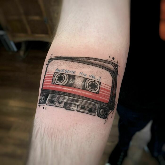 Marvel tattoo of a retro cassette tape design labeled "Awesome Mix Vol. 1" on an arm.