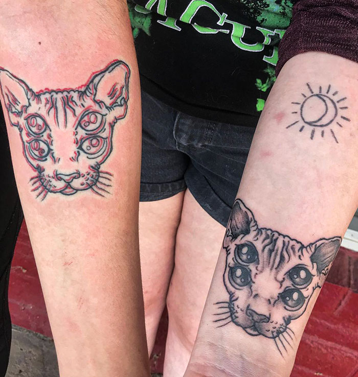 Matching BFF tattoos of multi-eyed cats on forearms, symbolizing friendship and creativity.