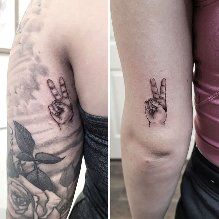 Matching best friend tattoos of a hand showing a peace sign on two people's arms.