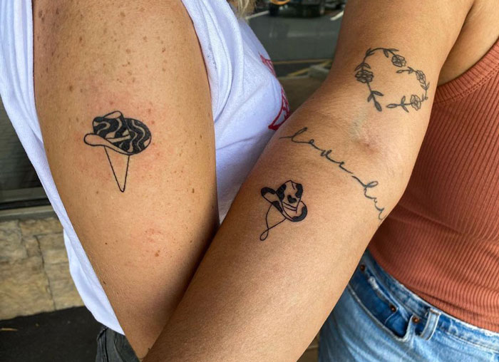Friendship tattoos on two people, featuring a detailed hat design and floral elements, symbolizing their bond.