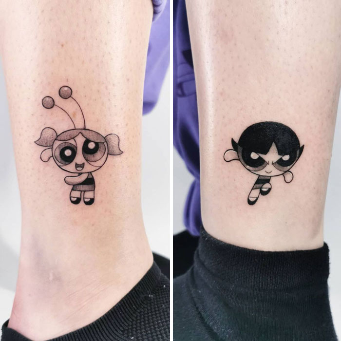 Matching best friend tattoos featuring cartoon characters from Powerpuff Girls on legs.