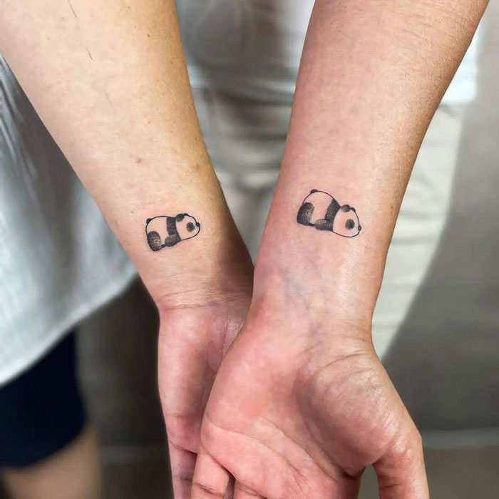 Matching panda BFF tattoos on two wrists, symbolizing friendship and shared experiences.