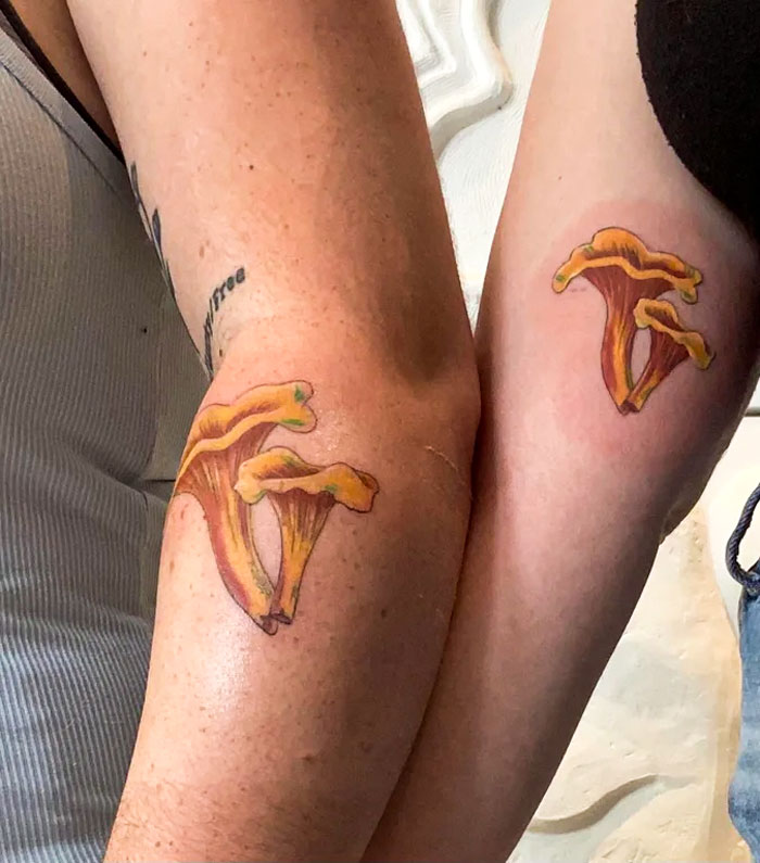 Two arms with matching mushroom BFF tattoos, symbolizing friendship and shared adventures.