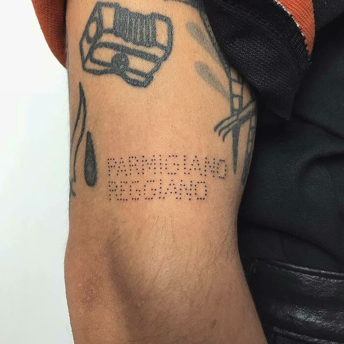 Creative word tattoos featuring "Parmigiano Reggiano" inked on an arm for inspiration.