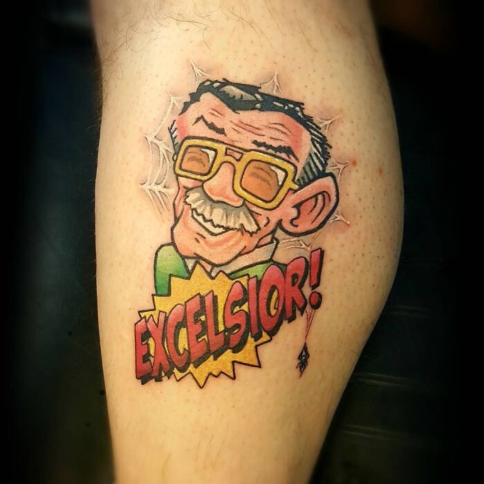 Marvel tattoo featuring a cartoon style portrait with the text "Excelsior!" in bold, colorful letters.