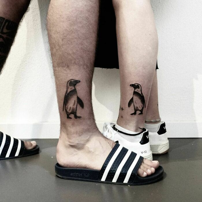 Brother and sister show matching penguin tattoos on their ankles, symbolizing their close bond.