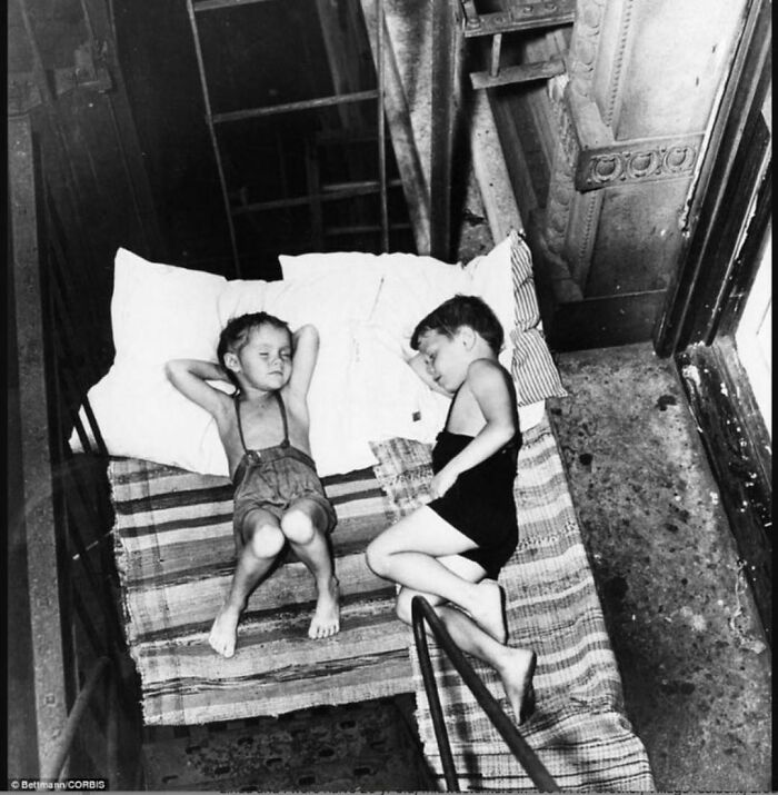 Two young kids sleeping in a buildings shaft 