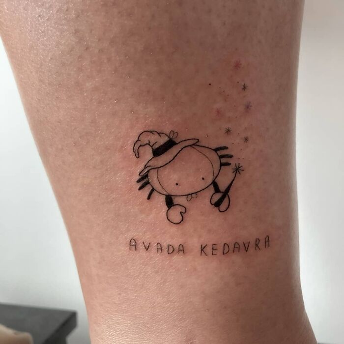Cartoon crab with a wizard hat and wand tattoo, featuring "Avada Kedavra," perfect for Harry Potter fans.