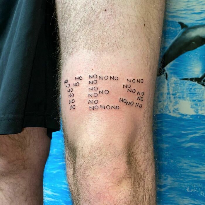 Word tattoo on a leg featuring the word "NO" repeatedly in a creative formation.