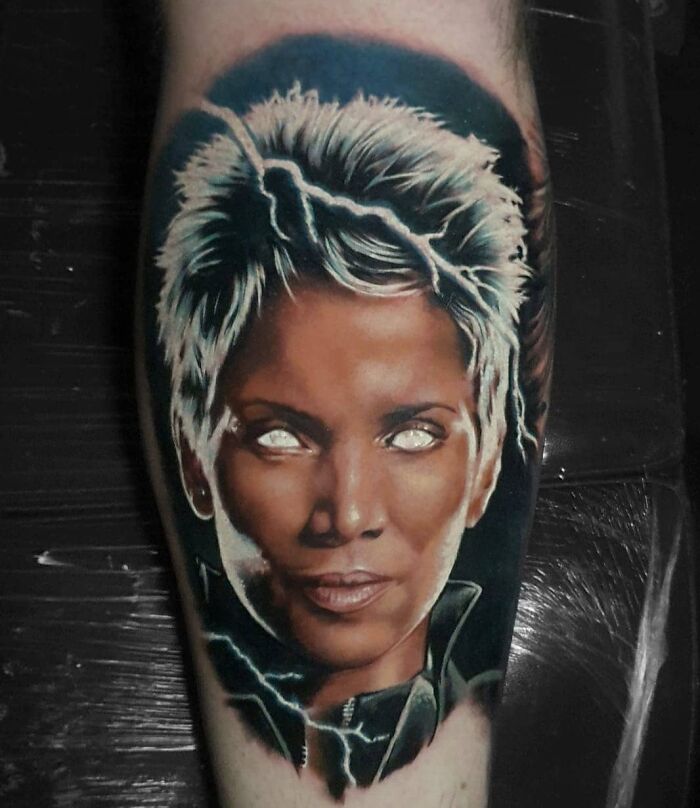 Marvel tattoo featuring a superhero with white hair and glowing eyes on a dark background.