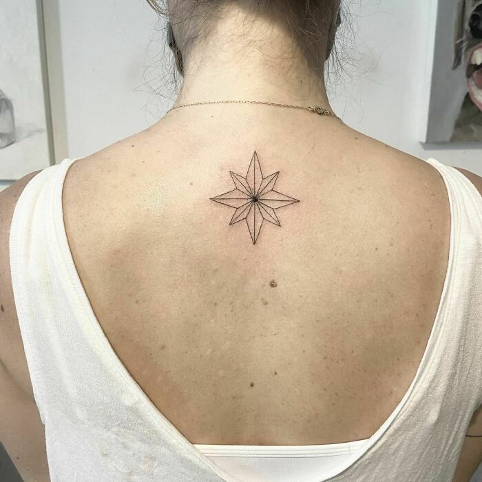 Minimalist star tattoo on upper back, showcasing a cool Marvel-inspired design.