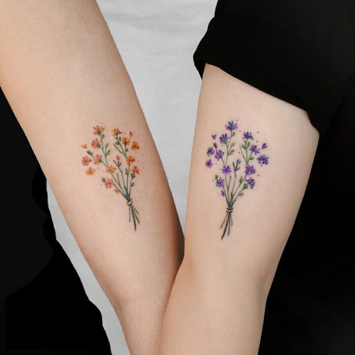 Matching floral BFF tattoos on forearms, featuring orange and purple flowers.