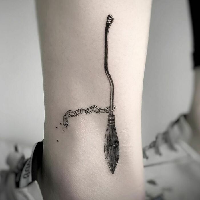 Minimalist Harry Potter tattoo featuring a chained broomstick on ankle.