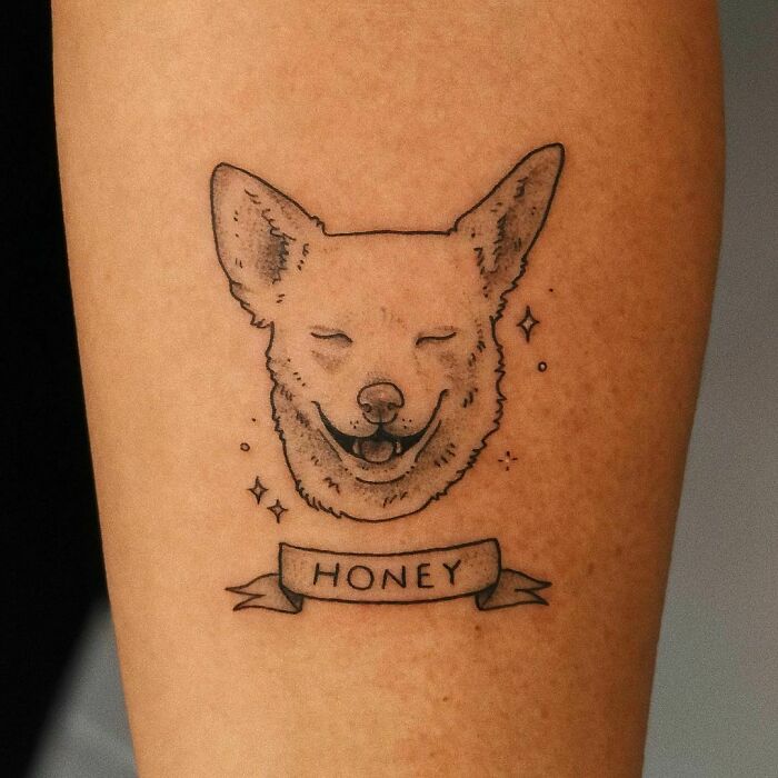 Pet tattoo of a smiling dog with "Honey" banner, highlighting the bond between humans and their pets.