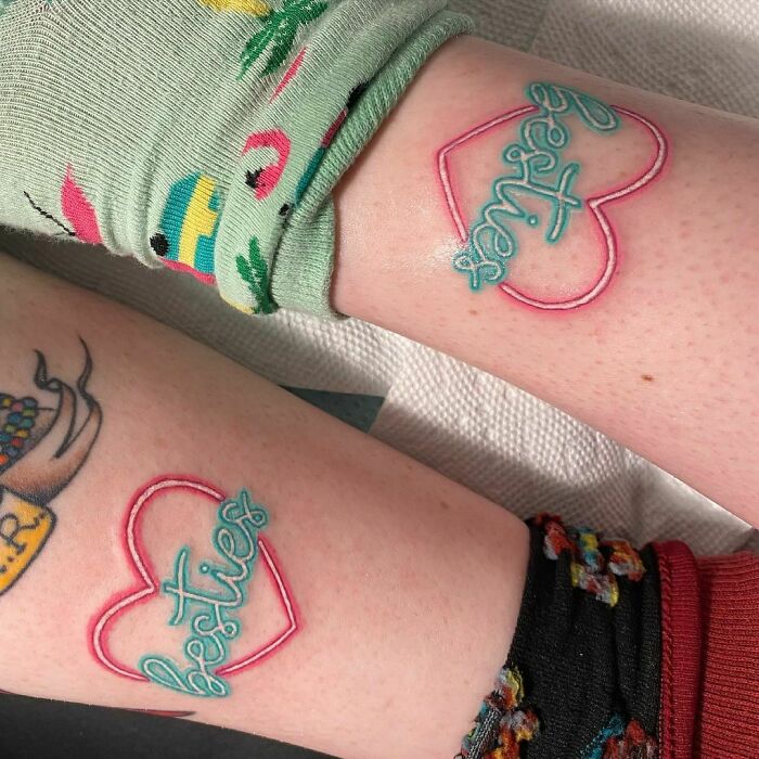 Matching "besties" tattoos on arms, symbolizing friendship.