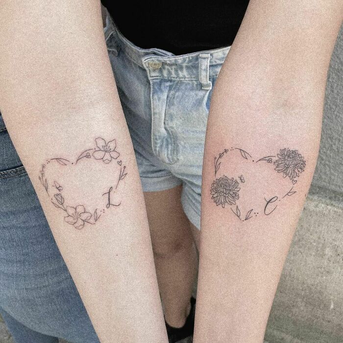 Brother and sister tattoos featuring floral heart designs on forearms with initials L and C, symbolizing sibling bond.