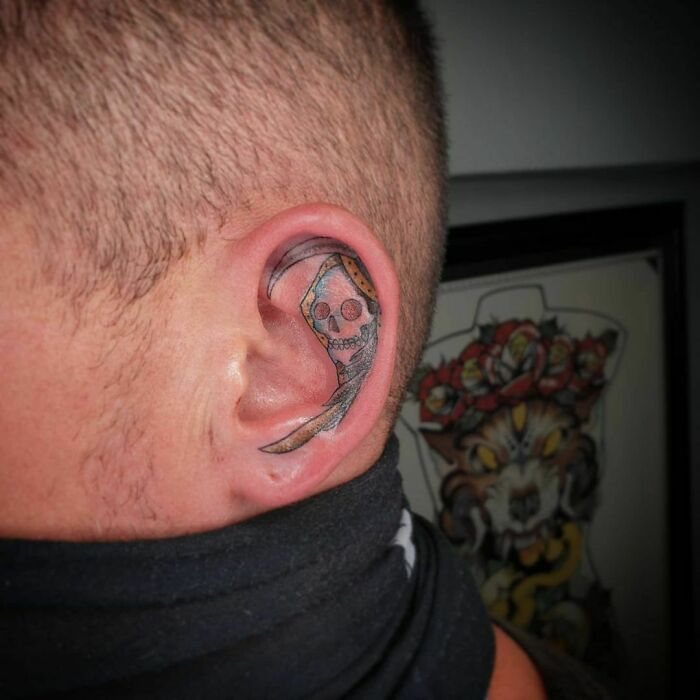 Skull-themed ear tattoo with bold colors and intricate details.