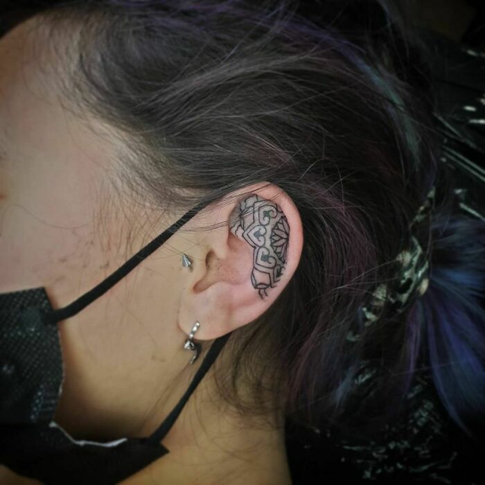Intricate ear tattoo design with geometric patterns, showcasing creative ear tattoo ideas.