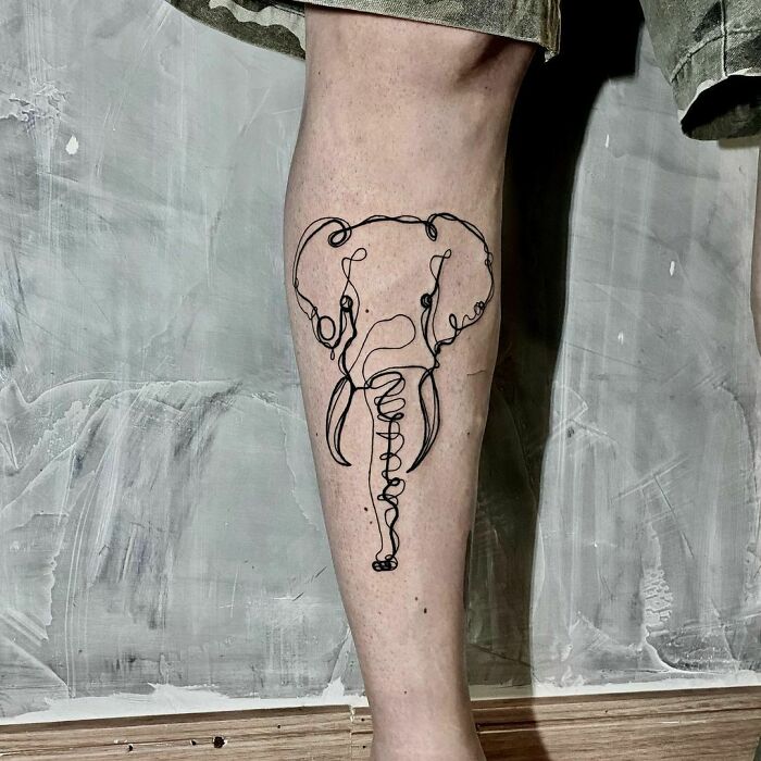 Line tattoo of an elephant on a leg, showcasing a minimalist design.