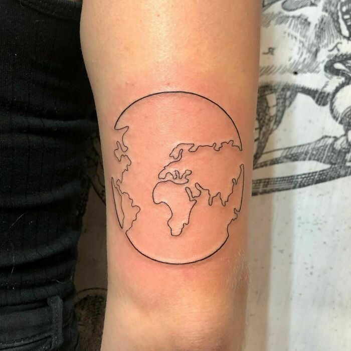 Single-line fine-line earth tattoo on arm, showcasing minimalist world map design.